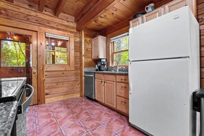 A wooden cabin interior with a kitchen area, including cabinets, a refrigerator, and a coffee maker. - Cozy Mountain Retreat w Pools &Free Attraction Tix (Pigeon Forge)