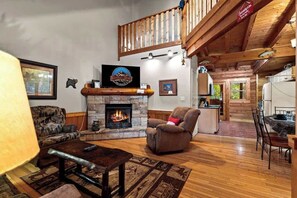 Una sala acogedora con chimenea, un sillón cómodo y un comedor.