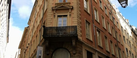 A corner building with a sign for 'Les Tom's Flingueurs' and a no entry sign.