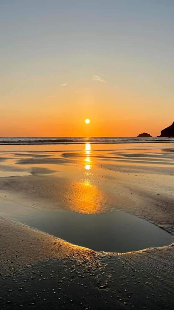 A beach at sunset with calm waters reflecting the sky. - Seaside Bungalow Retreat in Davidstow (Camelford)