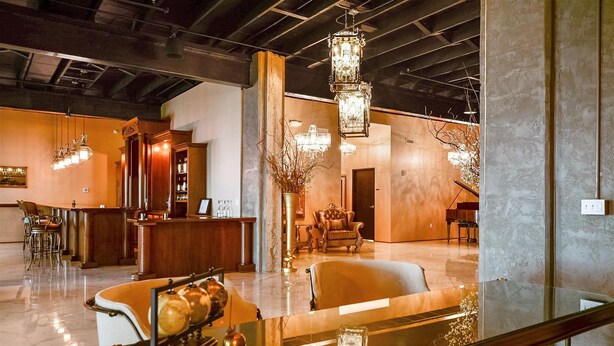 A spacious lobby with a reception desk, seating area, and a staircase. - Hotel 21 & Co. (Gering)