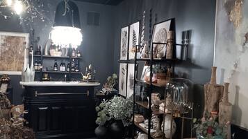 A well-organized bar area with shelves of bottles, a chandelier, and various decorative items.