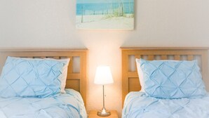 A bedroom with two beds, a nightstand with a lamp, and a beach-themed painting on the wall. - 3BR Family Resort Townhouse - Lazy River & Water Slide - Disney 15 Min (Davenport)