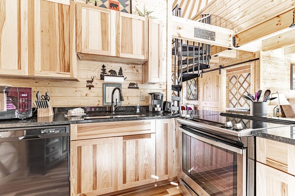 A kitchen with wooden cabinets, a dishwasher, a stove, and a coffee maker.