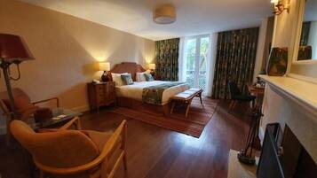 Ein Hotelzimmer mit Bett, Schreibtisch, Stuhl, Lampe und Kamin.
