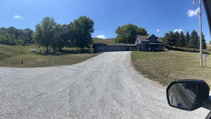 A gravel road leading to a large two-story building with a barn. - Heart of the Loess Hills (Moorhead)