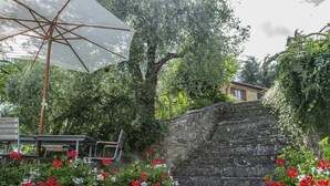A stone staircase leading up to a house, surrounded by lush greenery and red flowers. - Villa San Lorenzo - Large private farmhouse style villa (Grezzano)