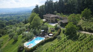A large stone house with a swimming pool surrounded by lush greenery and vineyards. - Villa San Lorenzo - Large private farmhouse style villa (Grezzano)