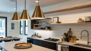 A modern kitchen with pendant lighting, a central island, and a built-in dishwasher. - Welcome to Summersalts at Lake Chelan (Chelan)