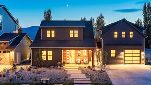 A two-story house with a well-lit front entrance, a garage, and a driveway. - Welcome to Summersalts at Lake Chelan (Chelan)