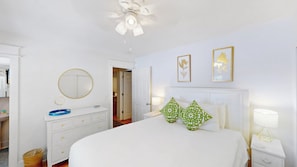 A bedroom with a bed, bedside tables, a dresser, a mirror, and two framed pictures on the wall. - Daydream Oasis with private pool, screen porch with dining, sleeps 8! (Isle of Palms)