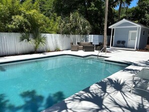 A swimming pool with a white deck, surrounded by a white fence and palm trees. - Daydream Oasis with private pool, screen porch with dining, sleeps 8! (Isle of Palms)