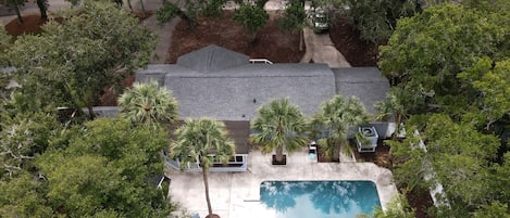 Una propiedad residencial con piscina, rodeada de abundante vegetación y árboles.
