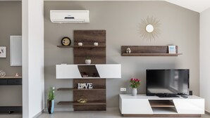A modern living room with a flat-screen TV, wooden shelves, a decorative sunburst mirror, and a potted plant. - Apartments Villa Salona Sky - Superior Two Bedroom Apartment with Balcony (Solin)
