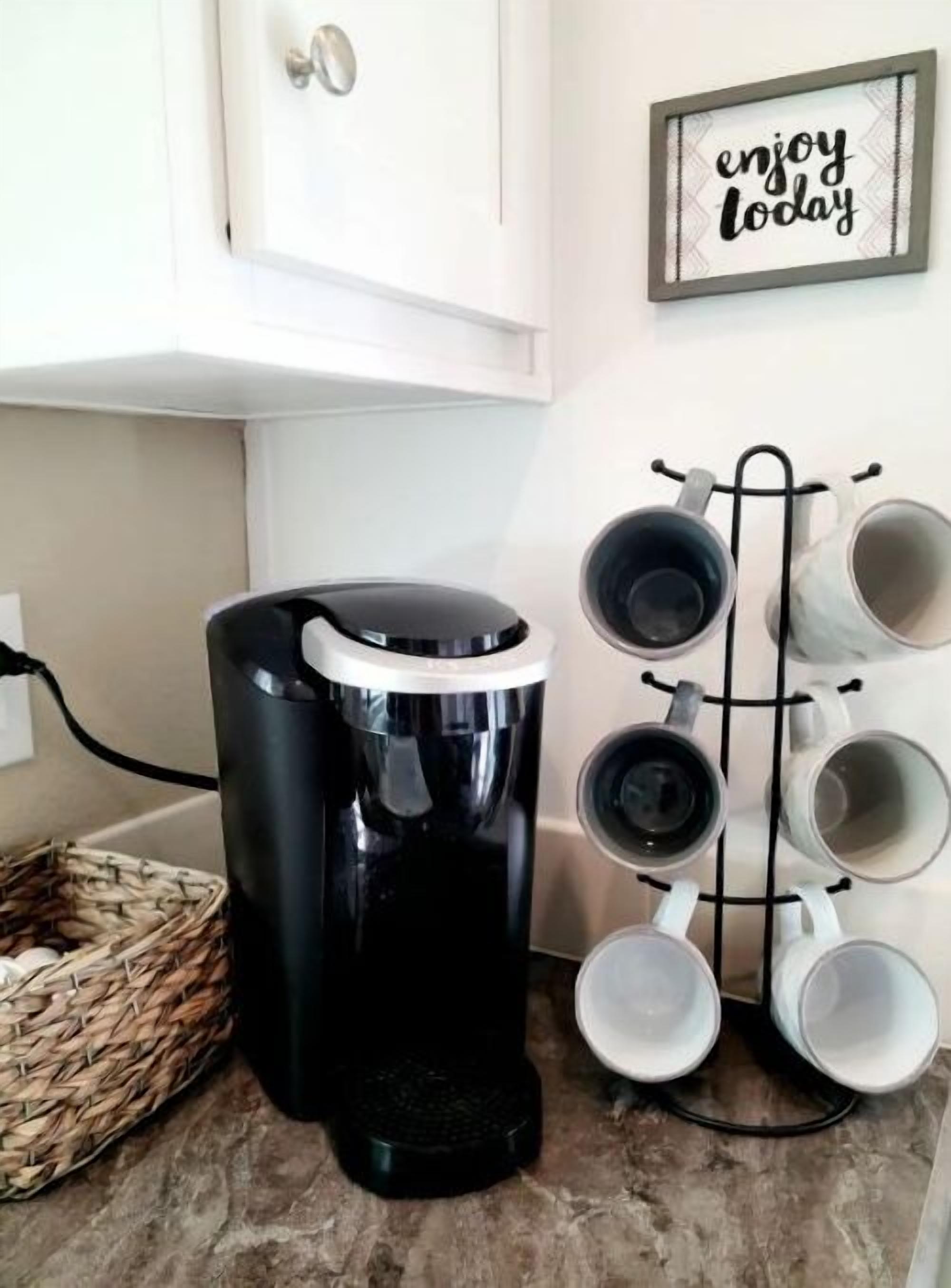 Une cuisine équipée d’une machine à café, d’un porte-tasses et d’un panier.