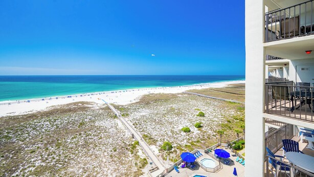 A beach view from a balcony with a pool and lounge chairs. - Relax by the Gulf in Luxury! Phoenix VI 61010 (Orange Beach)