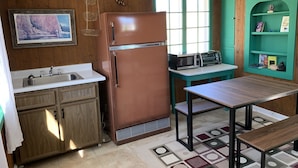 A compact kitchen with a refrigerator, microwave, and sink.