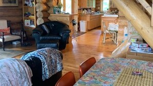 A cozy log cabin interior with a dining area, a kitchen, and a living room. - Private, Family/Pet-Friendly, Log Cabin on Waterfront Chicaugon Lake Property.   (Crystal Falls)