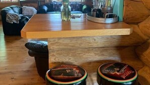 A rustic cabin interior with a wooden bar area, two stools, a coffee maker, and a vase with flowers. - Private, Family/Pet-Friendly, Log Cabin on Waterfront Chicaugon Lake Property.   (Crystal Falls)