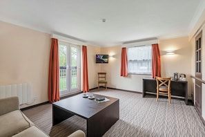 A hotel room with a large window, a flat-screen TV, a coffee station, and a seating area with a table and chairs. - Dragonfly Hotel Colchester Formerly Quality Hotel Colchester (Colchester)