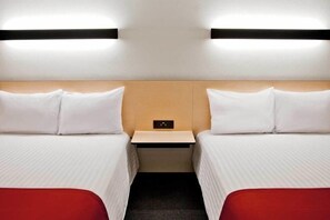 A hotel room with two beds, a small bedside table, and a wall-mounted light fixture. - City Express by Marriott Tehuacan (Tehuacan)
