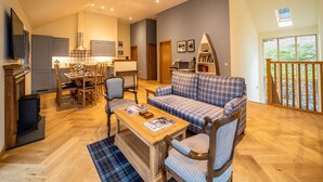 A spacious living area with a sofa, coffee table, and dining set.