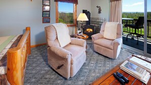 A cozy room with two plush armchairs, a fireplace, a wooden coffee table, and a view of the outdoors. - Nature Getaway, Menu breakfast served in your room (Cedar)