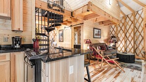 A wooden cabin interior with a kitchen, dining area, and a cozy living space. - Lush Comfort, great for couples or small family, Huge Deck w/Privte Hot Tub (Pigeon Forge)