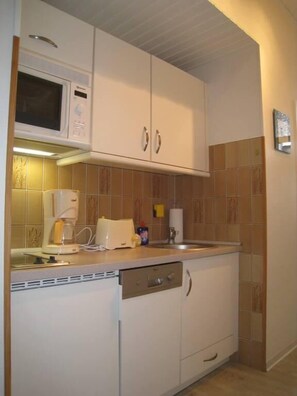 Een koelkast, een magnetron, een kookplaat, een vaatwasser