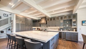 A spacious kitchen with a large island, grey cabinets, and a marble countertop. - MONTHLY LEASE - Luxury 4 BR 4 BA Truckee Available March 2022 (Truckee)