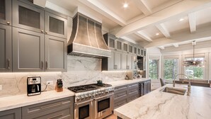 A modern kitchen with a large island, built-in appliances, and a high ceiling with exposed beams. - MONTHLY LEASE - Luxury 4 BR 4 BA Truckee Available March 2022 (Truckee)