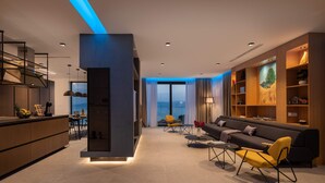 A modern living room with a sofa, chairs, a coffee table, and a bookshelf. - Wind Rose Wellness Villa Maestral (Marušici)