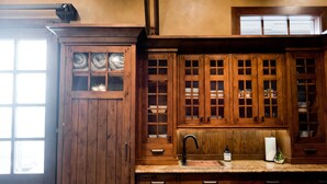 A kitchen with wooden cabinets, a granite countertop, and a window. - Depot Flat - Kitchenette, 2 Queen Murphy Beds, Large Sitting Area (Logan)