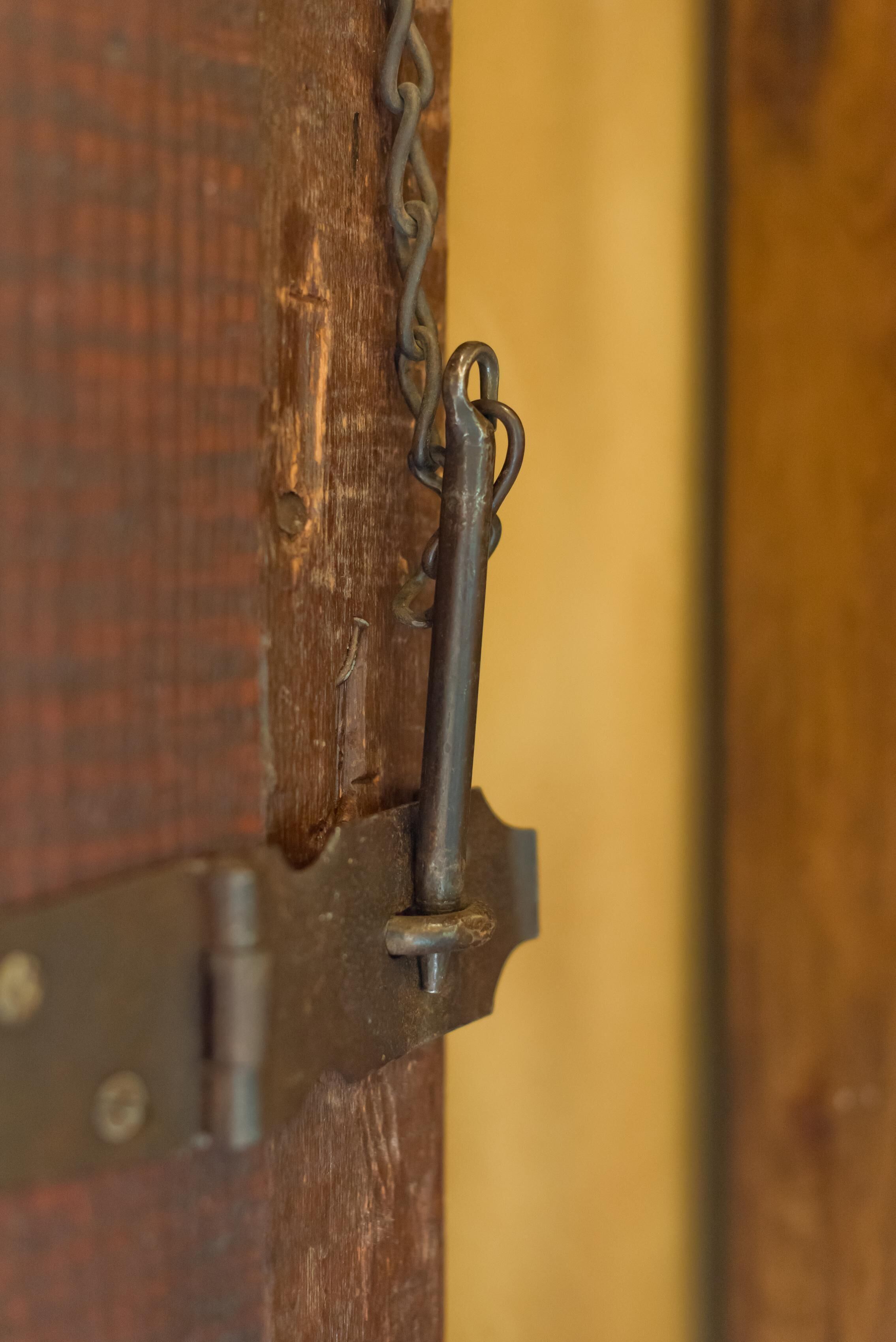 A close-up of a metal latch on a wooden door.
