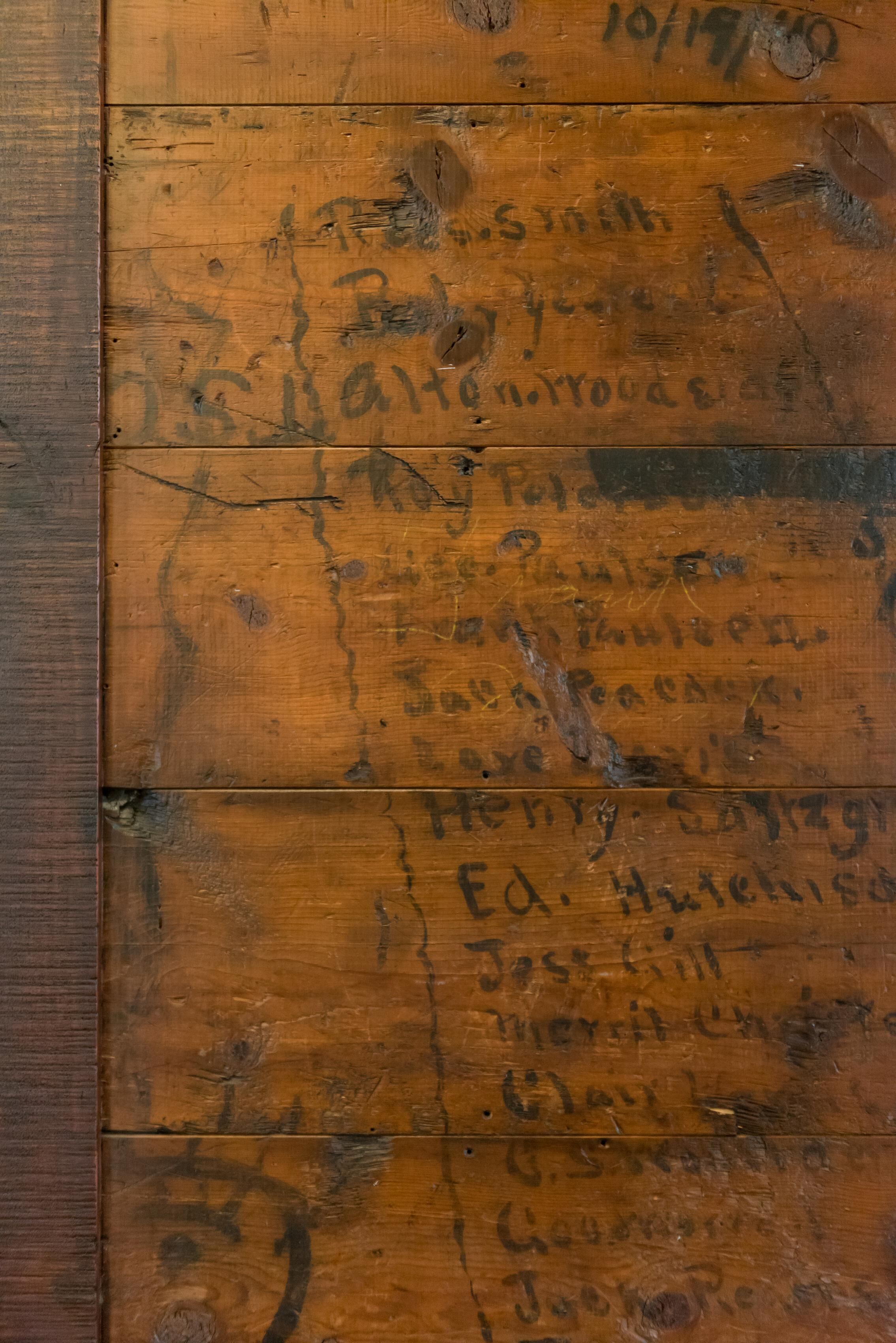 A wooden wall with visible wear and tear, including scratches and marks.