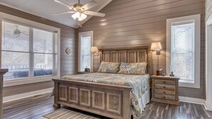 Ein Schlafzimmer mit einem hölzernen Bett, einem Deckenventilator und zwei Nachttischlampen.