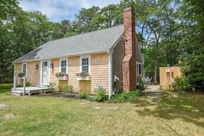 A single-story house with a brick chimney, a front porch, and flower boxes. - Great Home with Game Space, 0.8 miles from Cooks Brook Beach! (Eastham)