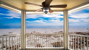 A covered porch with a ceiling fan, overlooking a beach with sand dunes and a clear sky. - Luxury Ocean Front Villa In Wild Dunes (Isle of Palms)