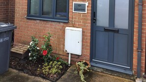 A brick house with a grey door, a window, and a number plate reading "121 Southwell Road".