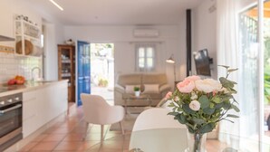 Eine moderne Küche mit Essbereich, einer Couch und einem Blumenstrauß auf einem Tisch.