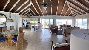A spacious living area with a kitchen, dining area, and a view of the ocean. - Ultimate USVI Views overlooking Caribbean & Salt River Bay Nat'l EcoPreserve (Christiansted)