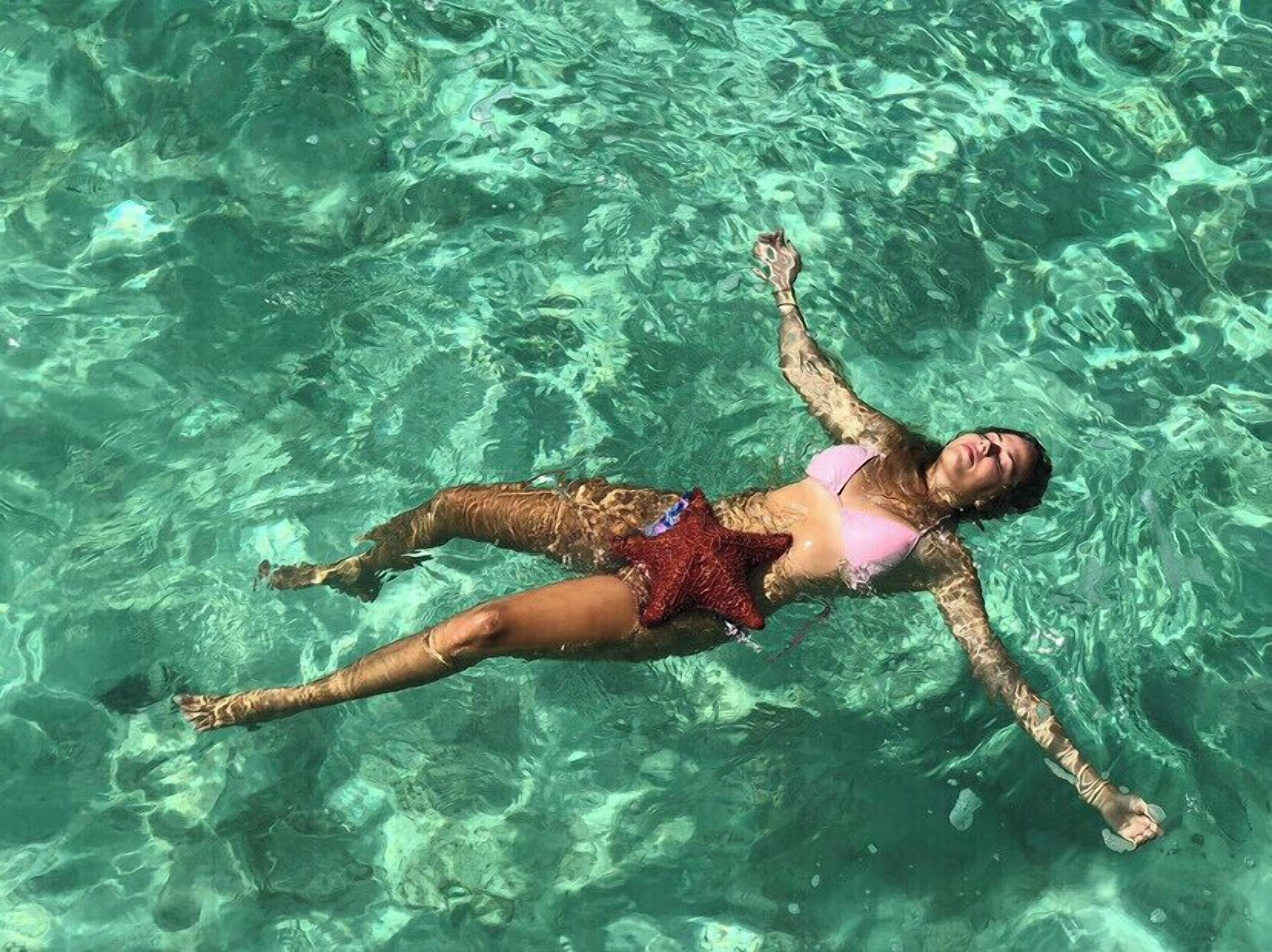 Una persona che galleggia in acqua limpida.
