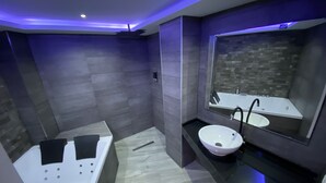 A modern bathroom with a bathtub, a sink, and a large mirror. - Luxury Gold (Linares)