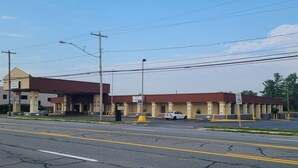 A motel with a red roof, a gas station, and a speed limit sign of 35 mph. - Dutchland Motel (Lancaster)