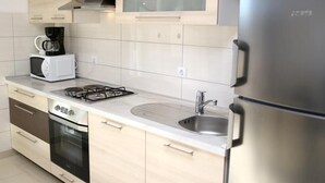 A modern kitchen with a gas stove, microwave, oven, stainless steel refrigerator, and a sink. - Remarkable 2-bed Apartment in Srima With sea View (Vodice)