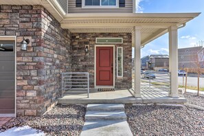Stylish entrance to a residential home with a covered porch and metal railing.