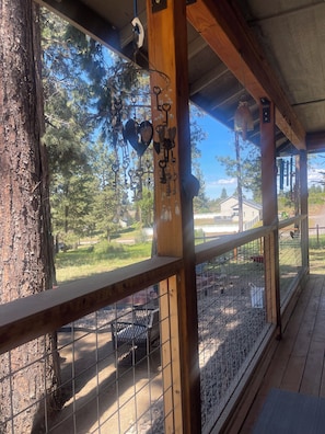 A wooden deck with a metal fence, a tree, and a view of a fenced area with a house in the background. - Beautiful Sunsets, Agency Lake, Mt McLaughlin, drive to Crater Lake and explore! (Chiloquin)