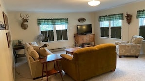 A living room with a sofa, a coffee table, a television, and a fireplace.