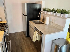 A compact kitchen with a refrigerator, sink, and stove. - Cozy 3BR Retreat Near DC - Pool & Playground (Annandale)