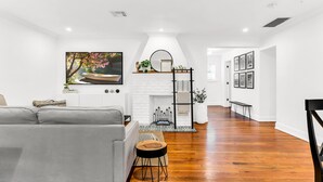 Una sala de estar moderna con una chimenea blanca, un sofá y una mesa de centro.
